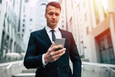 Şehir özgeçmişlerine smartphone kullanarak genç işadamı portresi