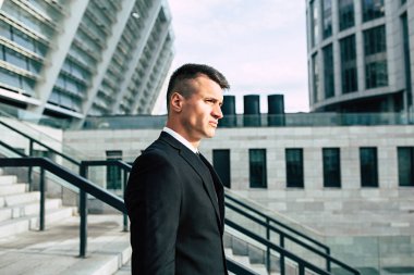 Modern şehir arka plan üzerinde kararlı genç işadamı