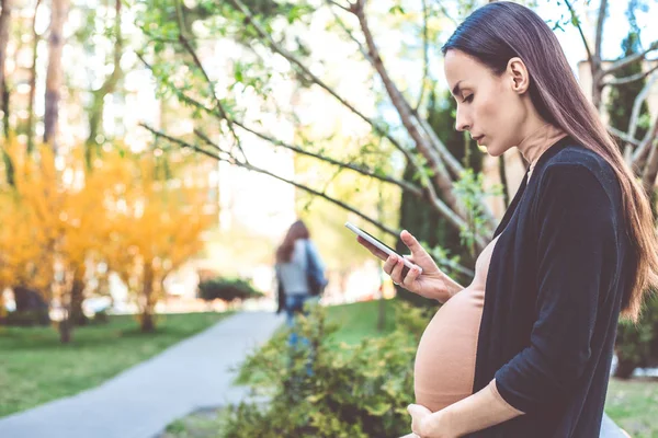 Mujer Embarazada Sentada Banco Parque Usando Teléfono Inteligente — Foto de Stock