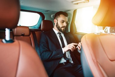 Arabada oturan smartphone kullanarak emin yakışıklı işadamı