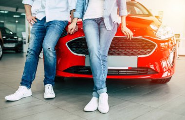 yeni arabanın yakınında duran ve birlikte elele çiftin Fotoğrafı kırp