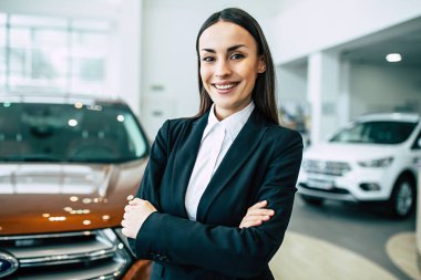 neşeli gülümseyen iş kadını ile Bayilik araba arka plan üzerinde çapraz silah siyah takım ayakta portresi