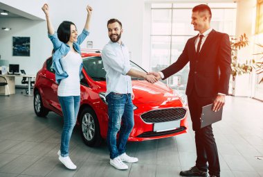 Sallayarak el ve yeni araba bayilik yakınında duran mutlu güzel kadın erkek