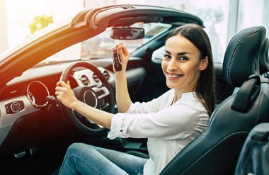 Yeni modern araç ve gösteren anahtar sürüş gülümseyen güzel kadın portresi