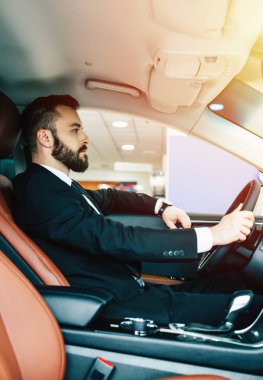 Arabayı kullanan takım elbiseli emin yakışıklı adam 