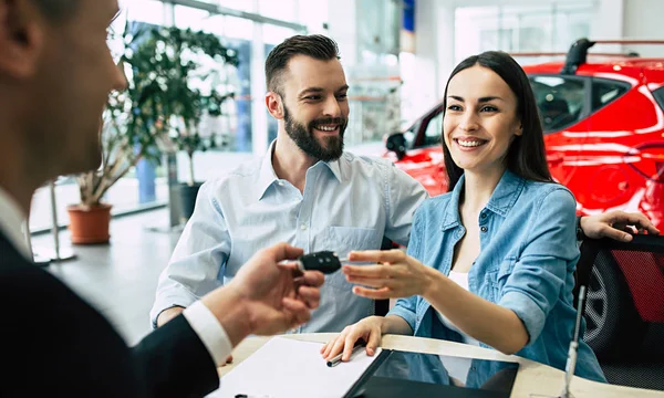 Gerente Masculino Dando Chave Carro Para Casal Feliz Sentado Mesa — Fotografia de Stock