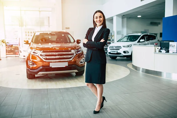 Beautiful Smiling Saleswoman Suit Standing Crossed Arms Dealership Cars Background — Stock Photo, Image