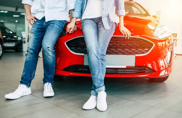 新しい車の近くに立って 一緒に手を繋いでいるカップルの写真のトリミング — ストック写真