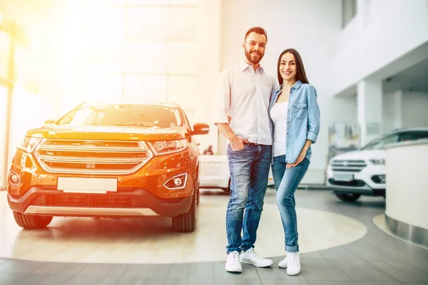 Mutlu genç çift rahat içinde sarılma ayakta yakınındaki yeni araba içinde Bayilik giymek.