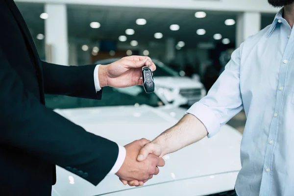 Men Shaking Hands Giving Automobile Keys Background Dealership Cars — Stock Photo, Image