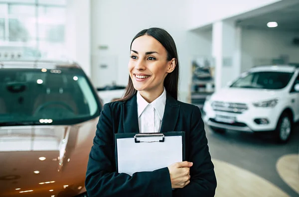 Smiling Saleswoman Suit Standing Documents Dealership Cars Background — Stock Photo, Image