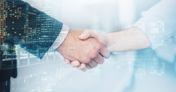 handshake of two businessmen with cityscape background, close up