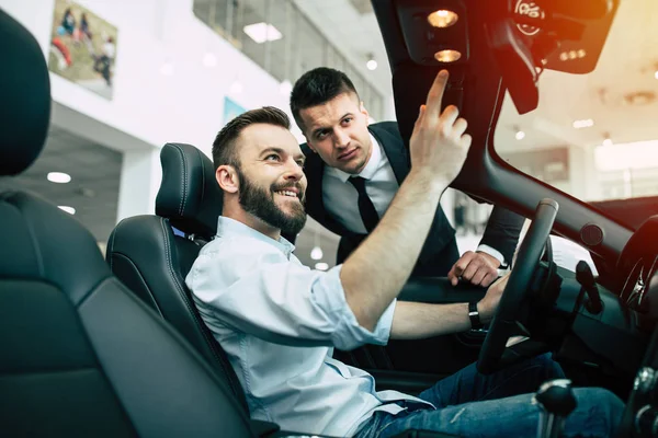 Sakallı adam yeni cabriolet galerisinde, onu ayrıntıları gösteren satıcı satın alma