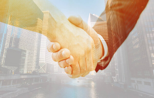 handshake of two businessmen with cityscape background 