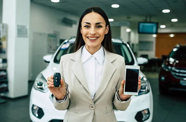 Beautiful Smiling Saleswoman Suit Car Keys Smartphone Hands Dealership Cars — Stock Photo, Image