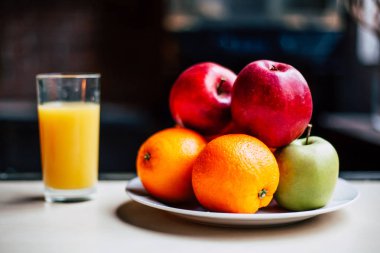 Mutfak konsepti. Beyaz bir tabak ve masanın üzerine portakal suyu bir bardak meyve kompozisyonu. Sağlıklı yaşam tarzı.