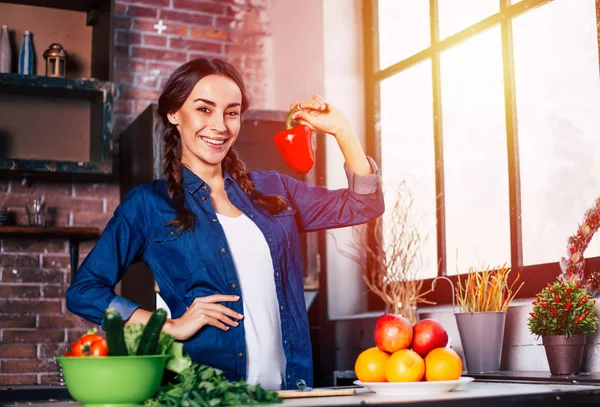 Jonge vrouw in de keuken. Gezonde voeding. Dieet. Dieet Concept. Gezonde levensstijl. Thuis koken. Eten bereiden. Zeer mooie vrolijke jonge brunette vrouw holding groenten en glimlachen. — Stockfoto