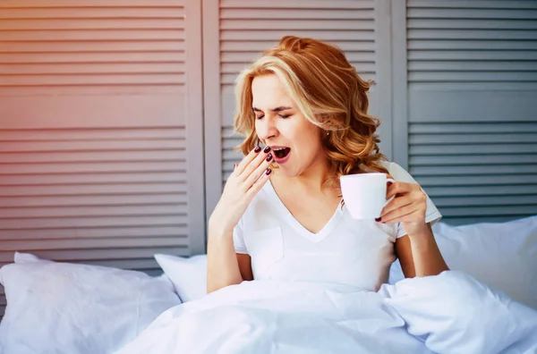 Γυναίκα πίνει καφέ στο κρεβάτι — Φωτογραφία Αρχείου