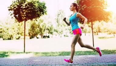 Genç atletik kadın parkta koşu