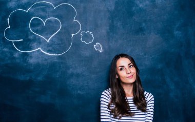 Genç esmer kızla kara tahta üzerinde konuşma balonu 