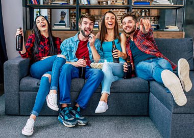 Bira içip patlamış mısır yeme oturma odasında genç arkadaş grubu 