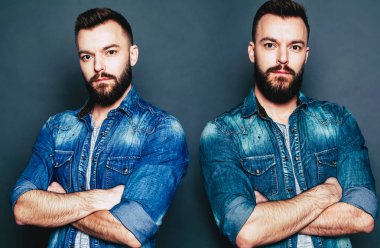 Genç hipster adam gri arka plan üzerinde tek kişilik etkisi poz