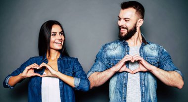 Çift kalpler elleriyle gri arka plan üzerinde yapma