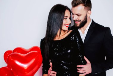 Genç çift beyaz arka plan üzerinde kırmızı balonlarla poz