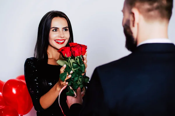 Young beard man gifting rose bouquet to girlfriend