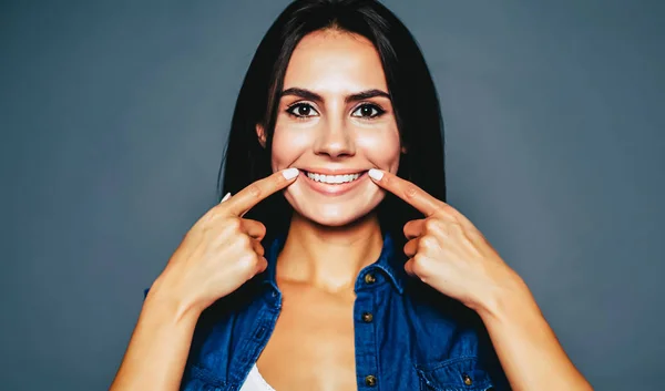 Mujer Joven Señalando Sonrisa Sobre Fondo Gris — Foto de Stock