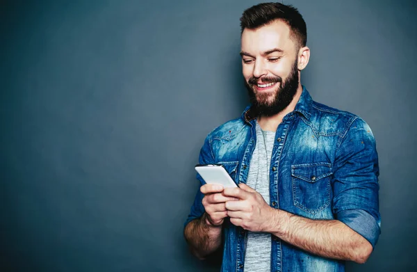 Joven Hombre Sonriente Sosteniendo Teléfono Inteligente Sobre Fondo Gris — Foto de Stock