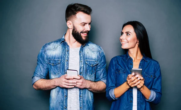 Ungt Par Använder Smartphones Grå Bakgrund — Stockfoto