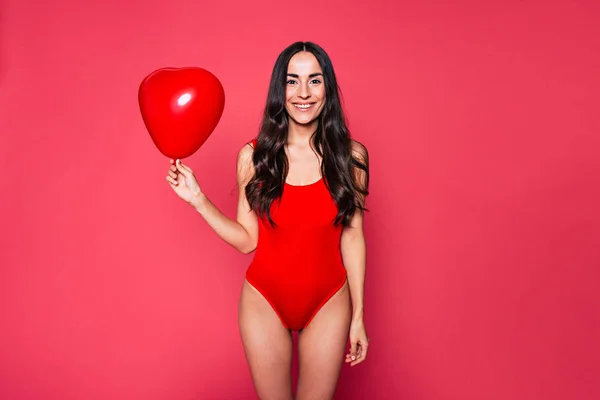Genç Esmer Kadın Kırmızı Mayo Balon Üzerinde Pembe Bir Arka — Stok fotoğraf