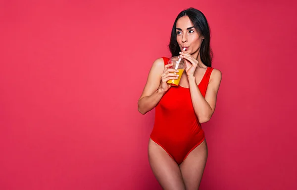 Genç Esmer Kadın Kırmızı Mayo Bardak Suyu Üzerinde Pembe Bir — Stok fotoğraf