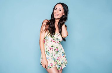 Genç esmer kadın mavi arka plan üzerinde poz