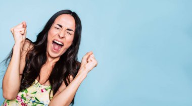 Genç esmer kadın mavi arka plan üzerinde çığlığı