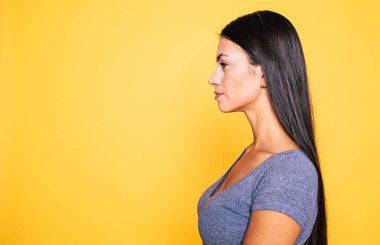 Genç esmer sarı arka plan üzerinde poz profili