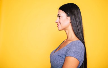 Genç esmer sarı arka plan üzerinde poz profili