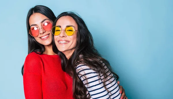 Portret Van Twee Stijlvolle Brunettes Zonnebril Poseren Blauwe Achtergrond — Stockfoto