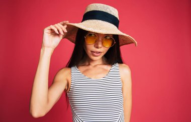 Şapka ve gözlük kırmızı zemin üzerine poz genç esmer portresi 