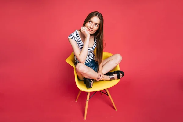 Retrato Una Joven Sentada Una Silla Sobre Fondo Rojo —  Fotos de Stock