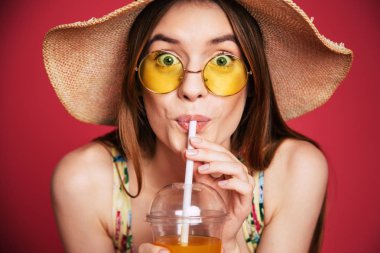 Taze kırmızı arka plan ile poz şapkalı genç kız portresi