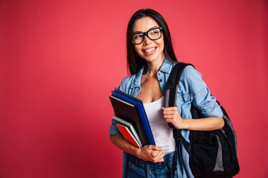 Genç esmer kırmızı zemin üzerine not defterleri ile poz portresi 