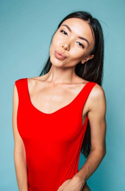 Genç esmer mavi arka plan üzerinde poz portresi 