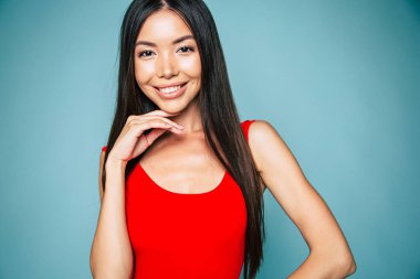 Genç esmer mavi arka plan üzerinde poz portresi 