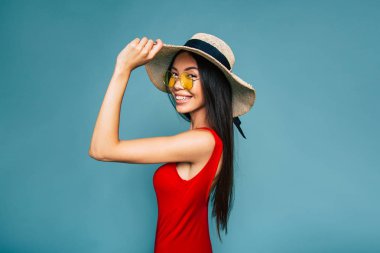 Mavi arka plan üzerinde şapkalı genç esmer portresi 