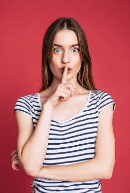 Sessizlik için ağzına bir parmak tutan düz saçlı güzel esmer kız