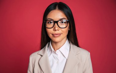 Genç işkadını kırmızı zemin üzerine gözlük sabitleme portresi