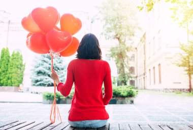 Balonlu kırmızı kazaklı kadın görünümünü el arka