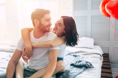 Genç heteroseksüel çift yatak odasında sarılma